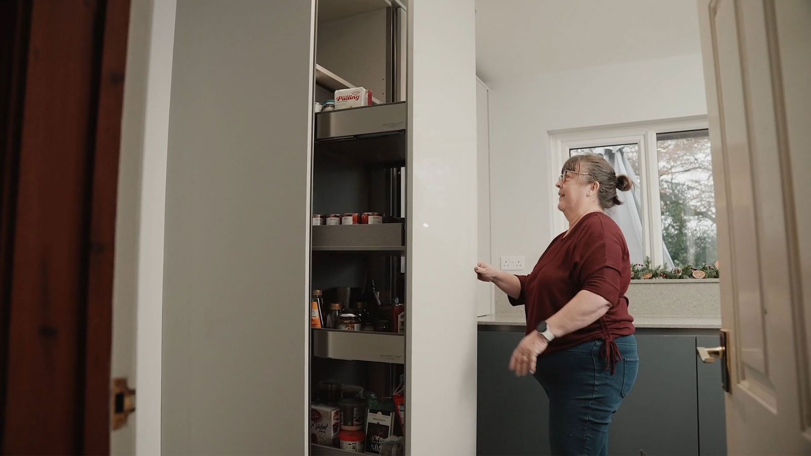 Gail accessing a corner larder unit which offers pull-out corner storage