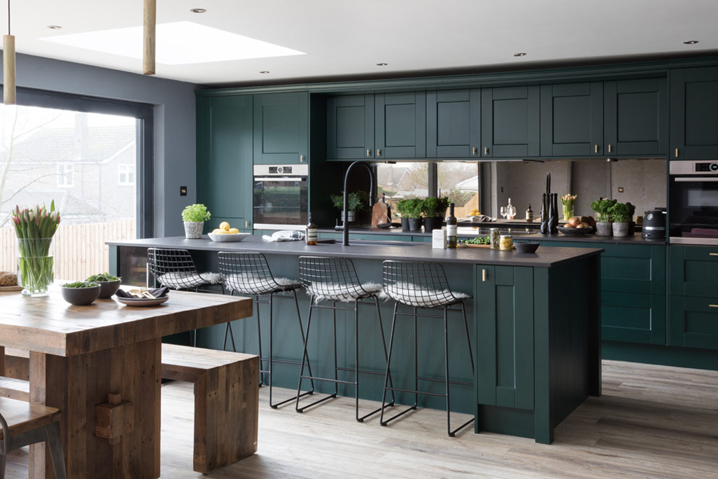 Dark green kitchen range with green kitchen island and black and gold fittings