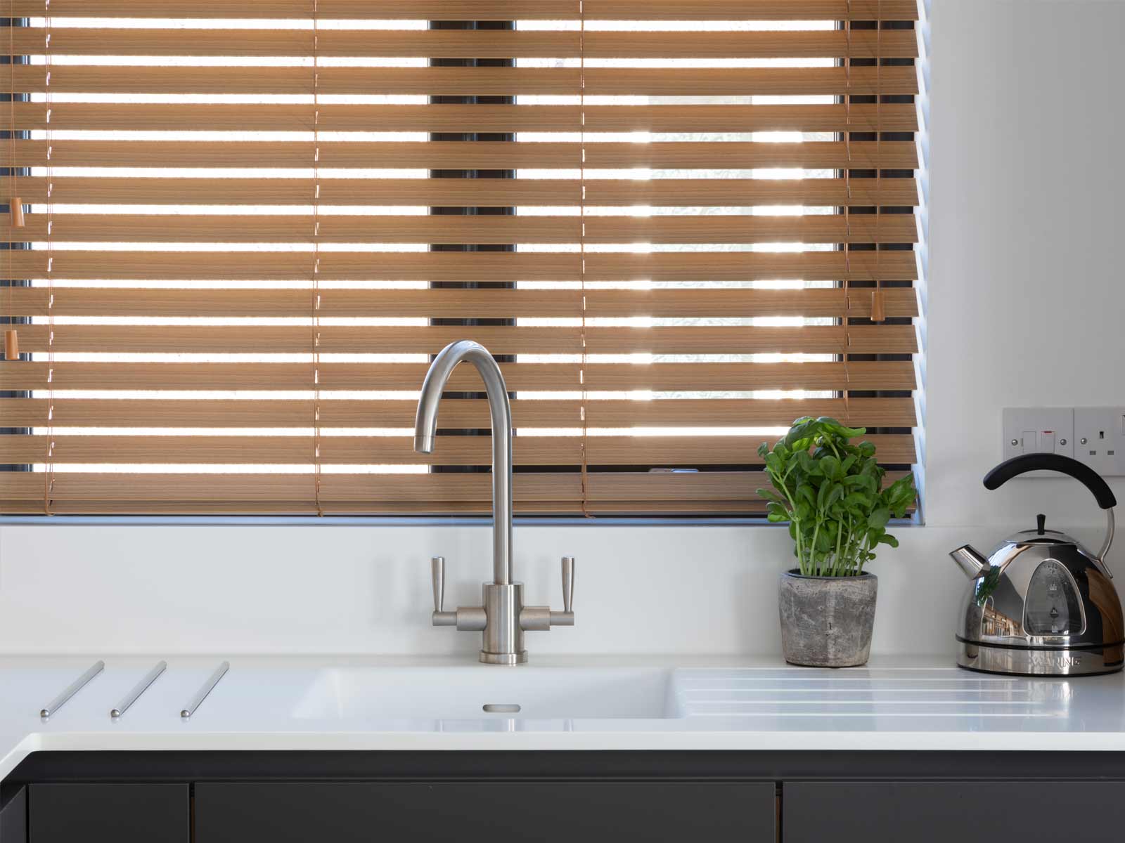 A sink showcasing biophilic theory principles under a kitchen window