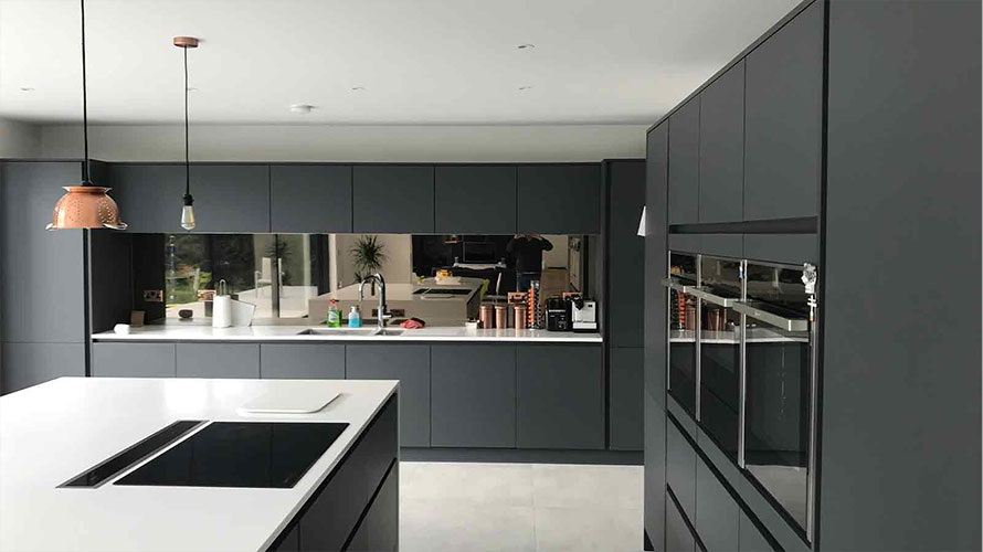 Mirror splashback in a dark kitchen