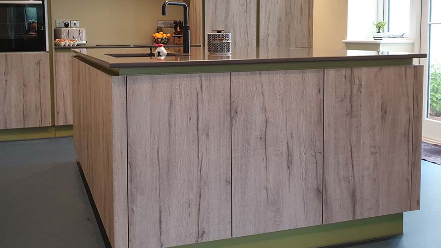 Handleless kitchen with green handle rail in Abergavenny