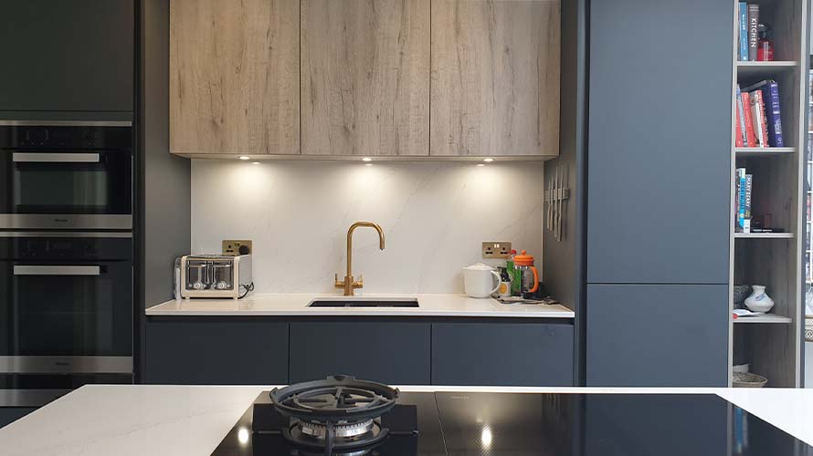 Dark handleless kitchen with wood finishes in Esher