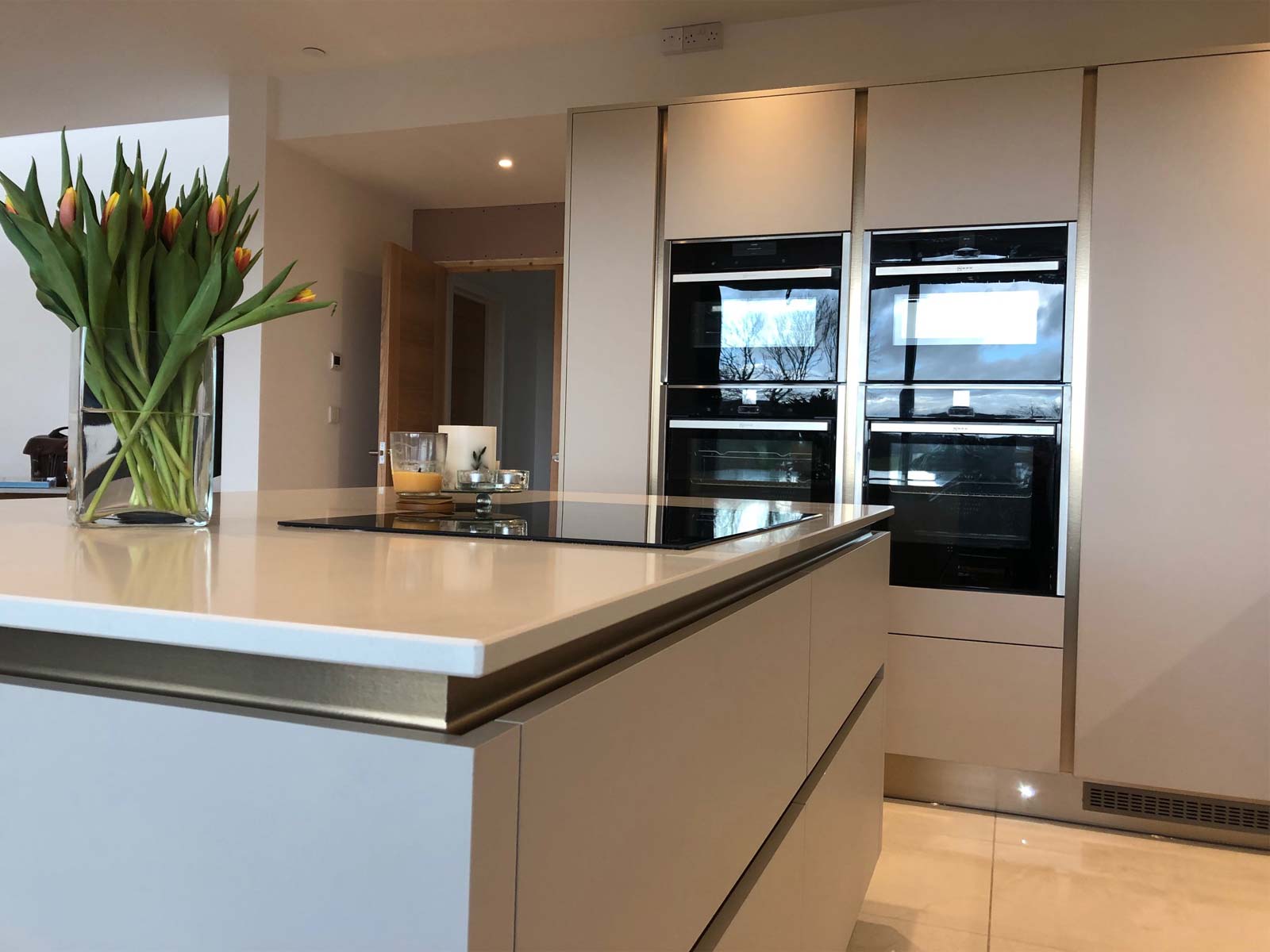 A modern cashmere kitchen with an off-white and gold colour palette