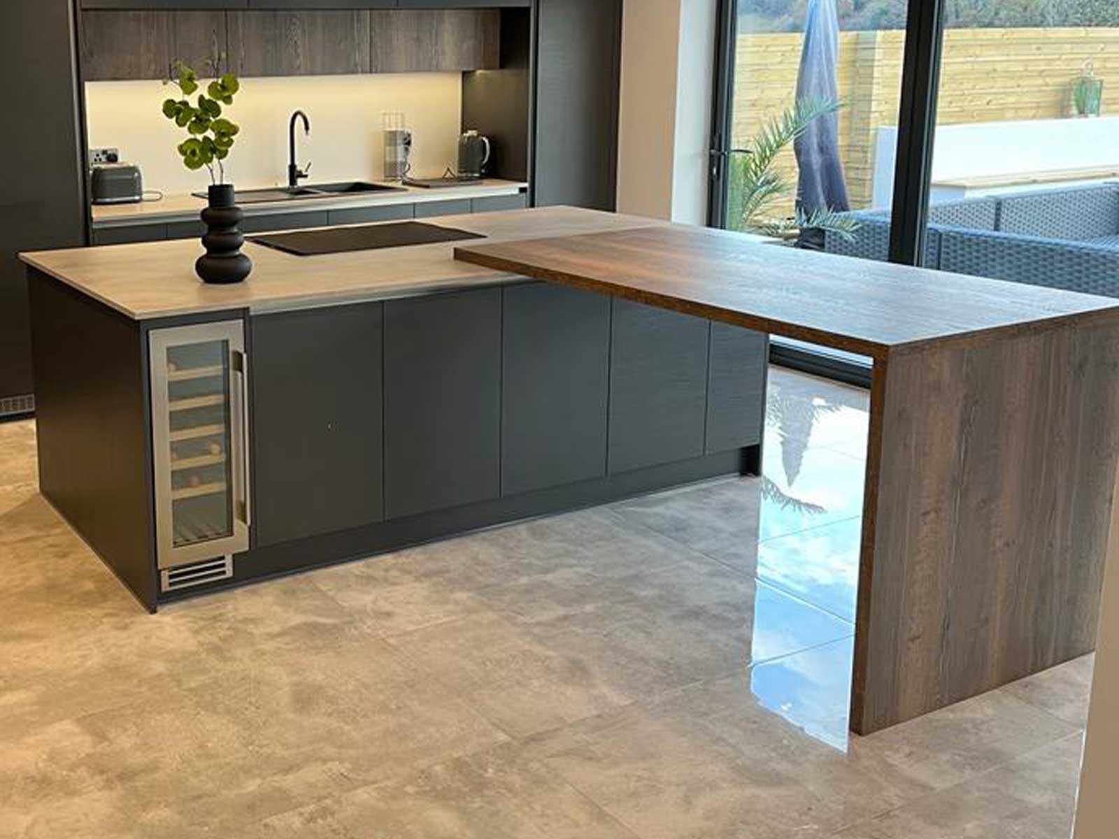 A breakfast bar unit attached as a kitchen peninsula to a kitchen island