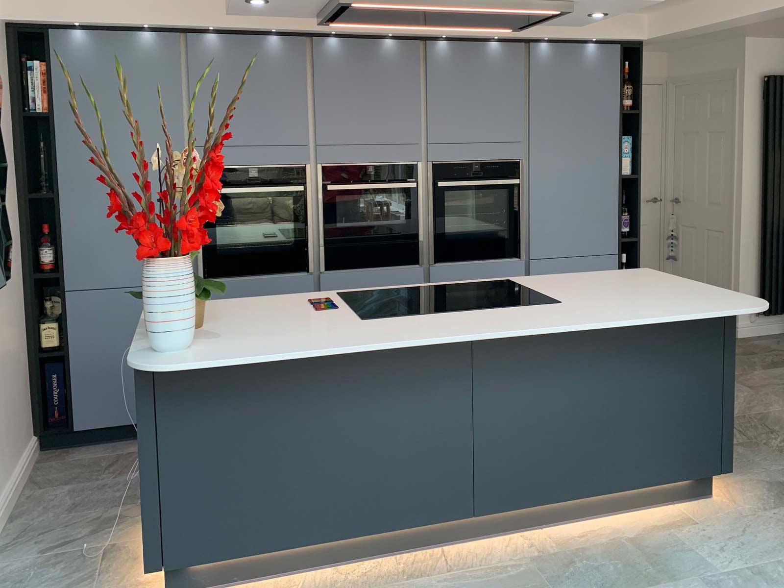 A contemporary grey kitchen with handleless doors and in-built oven