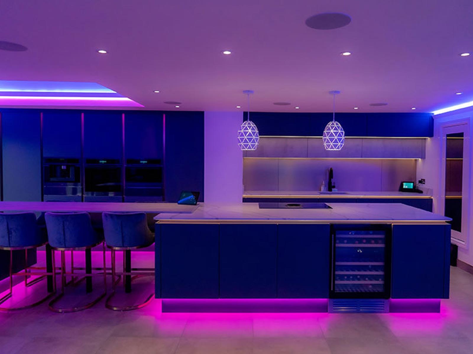 Home bar with dark blue doors, kitchen island lighting and kitchen strip lights