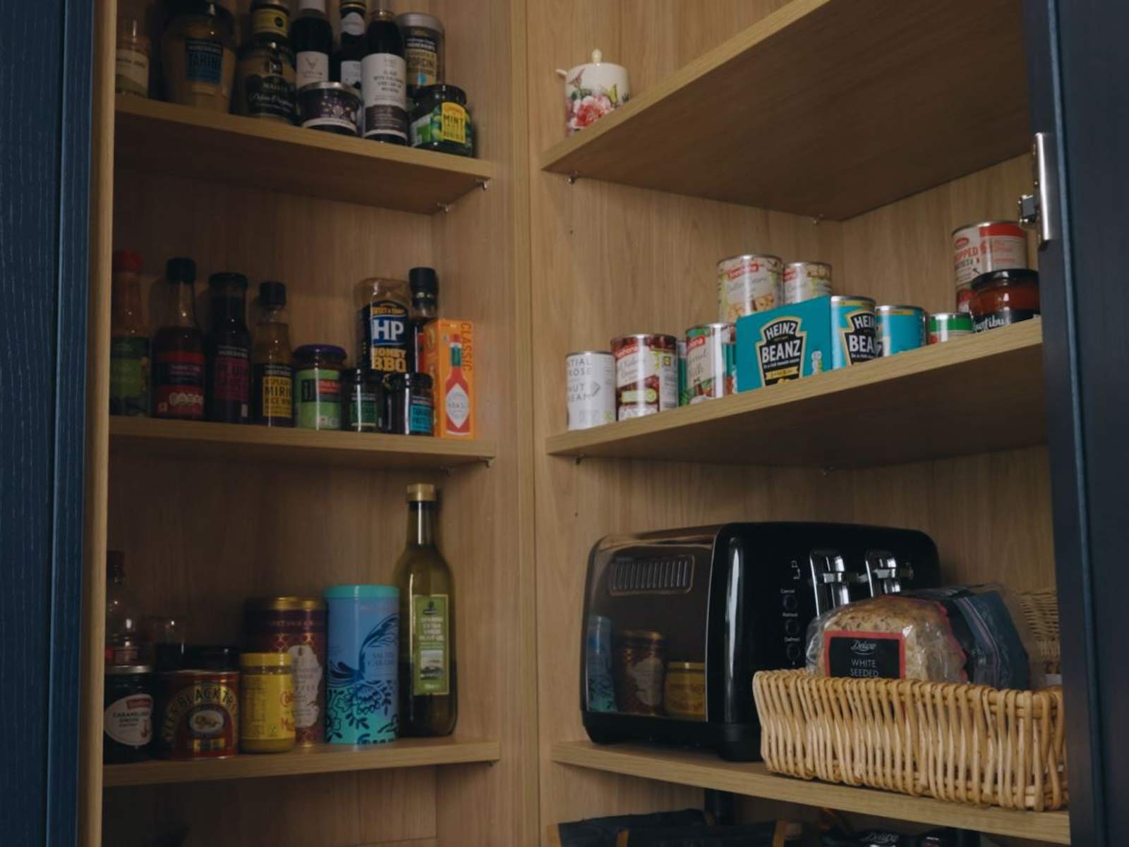 A pantry kitchen cabinet with shelves that match the home’s oak orangery