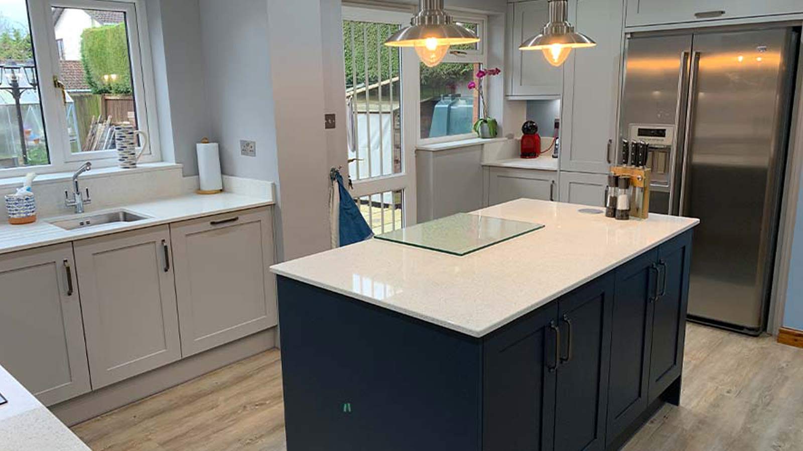 Blue kitchen island in a grey shaker kitchen