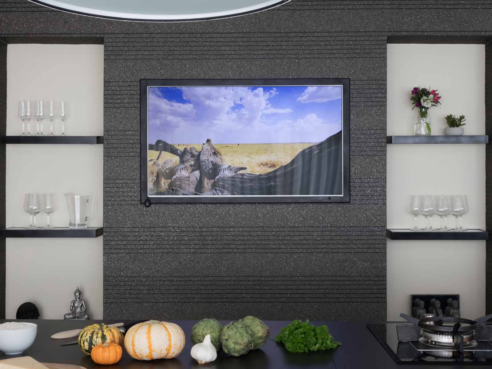 A simple media wall set opposite a kitchen island for a family