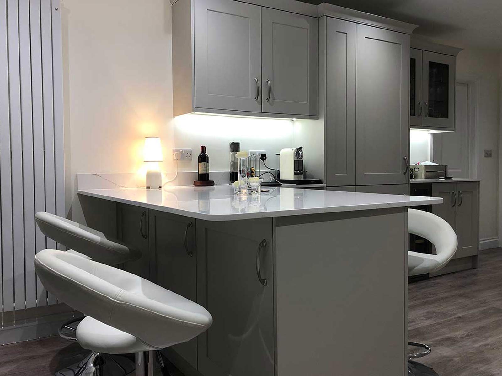 A kitchen peninsula counter with mobile kitchen island barstools