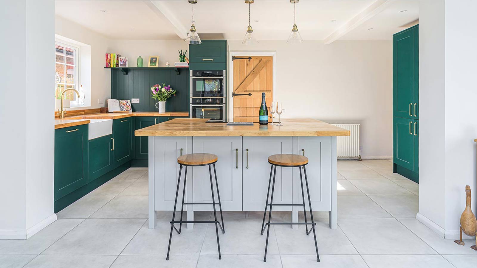 A clean kitchen with grey and green doors, symbolising cleaning life hacks