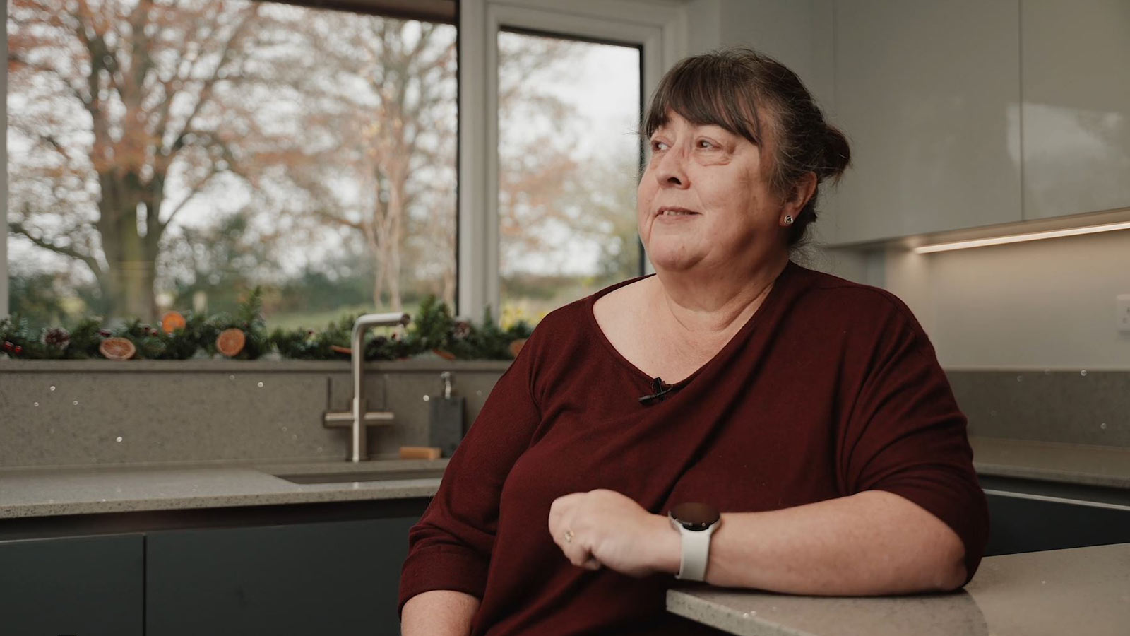  Gail at a corner dining table set out from her worktop as a kitchen peninsula