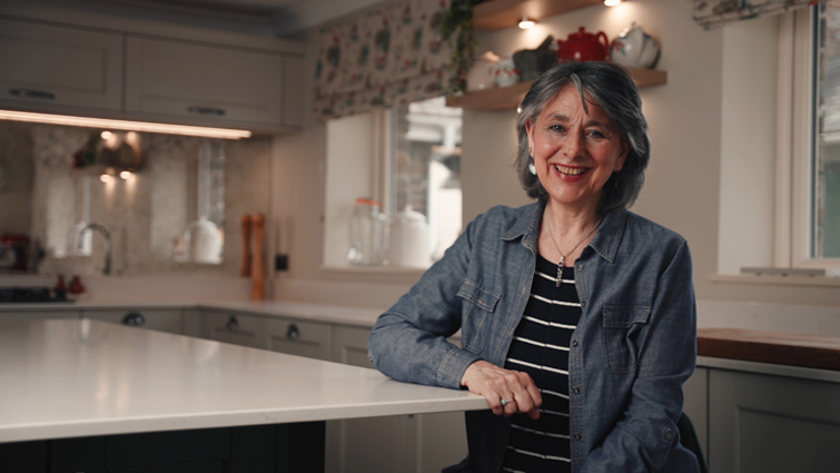 An open kitchen with Rita sitting at the welcoming kitchen island