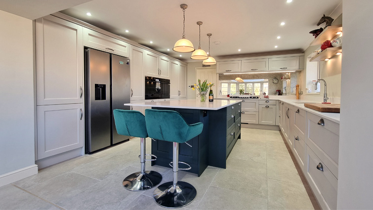 An open plan kitchen with island furniture and pendant lighting