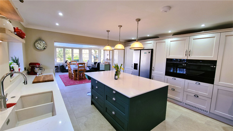 An open kitchen with a bright diner area with large windows