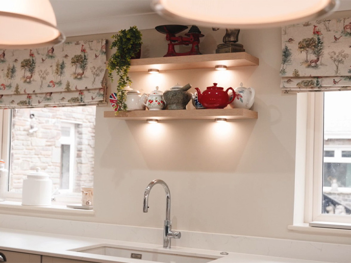 Open kitchen shelving with task lighting above a kitchen sink