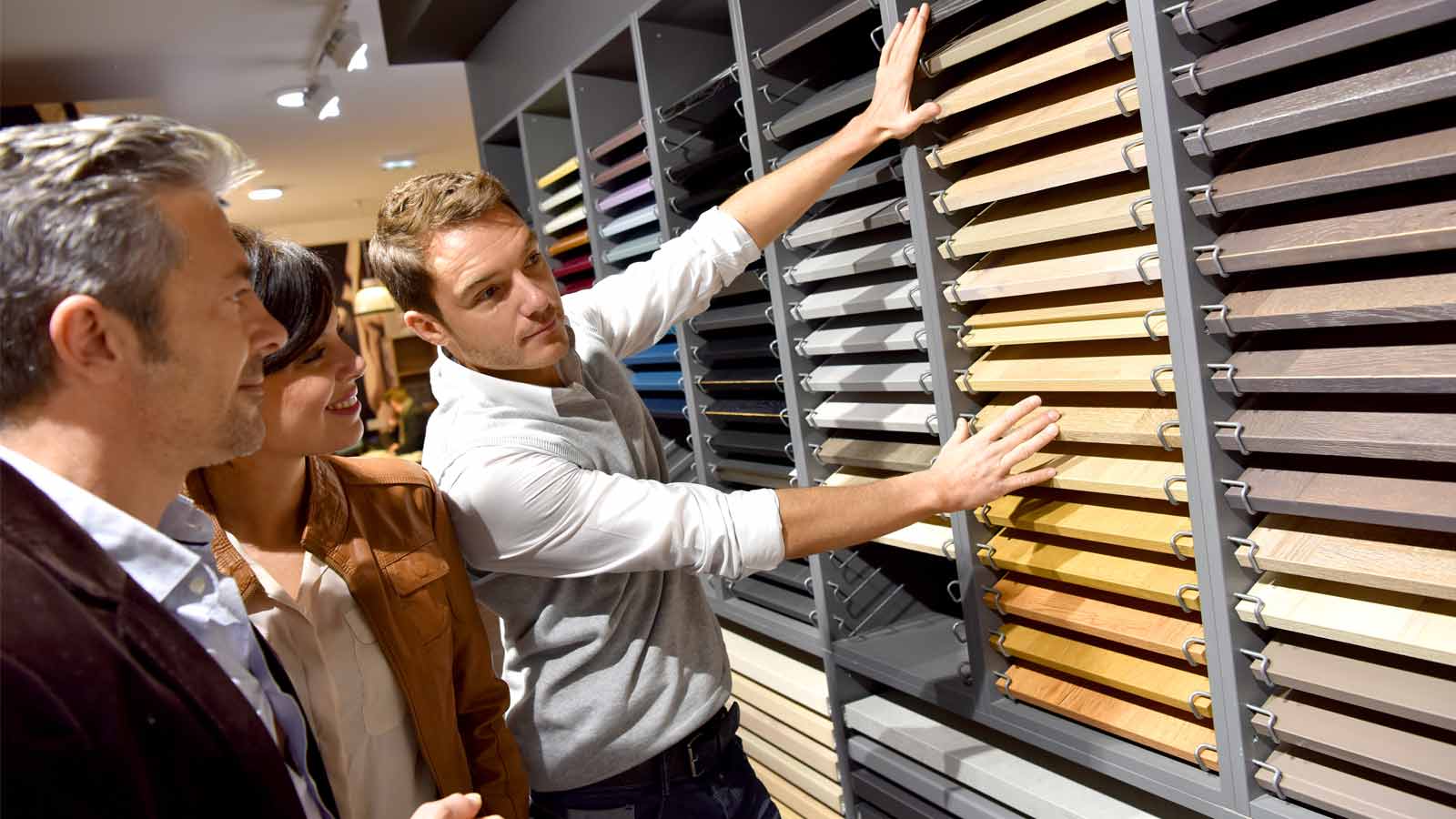 A kitchen designer showing clients around his kitchen supply store