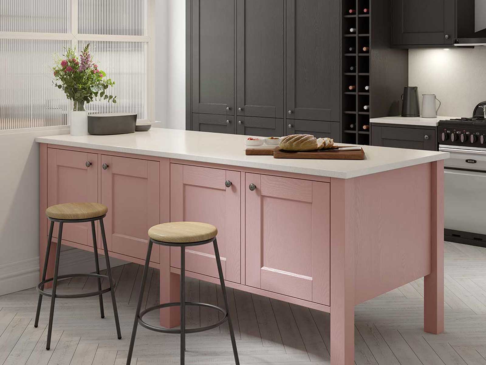 A pale pink Solva compact kitchen island fronting tall cabinets and a wine rack