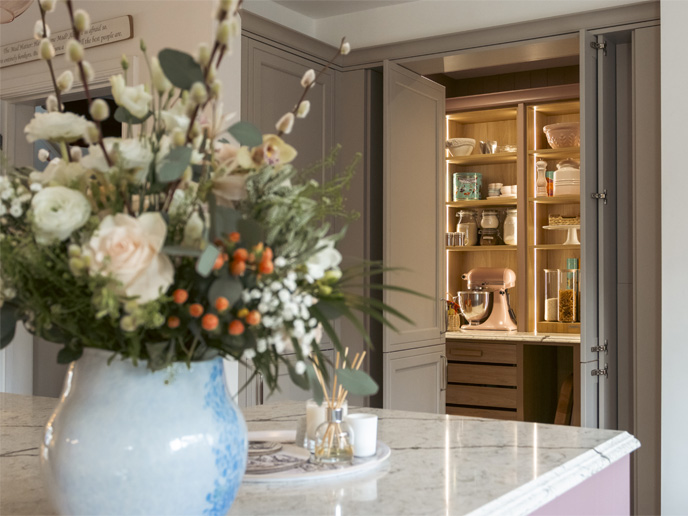 A large oak walk-in pantry with shelves and drawers