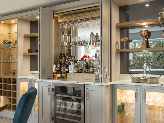 A hidden bar dresser with glass shelves and wine hooks