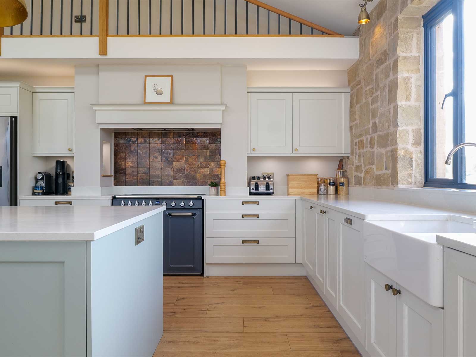 A kitchen with accent wall, kitchen island and Belfast sink