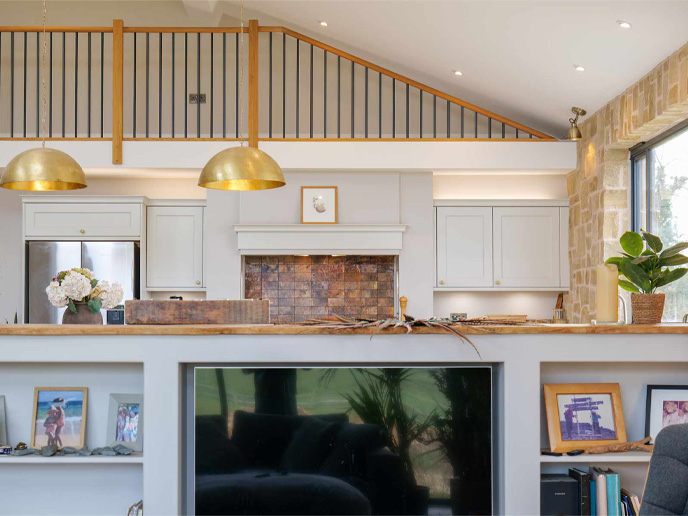 A high ceiling kitchen with a peninsula designed to create a kitchen zone