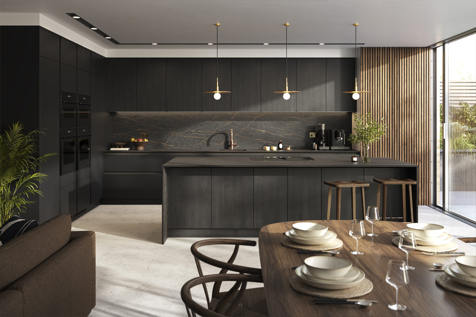 A room with black kitchen units alongside warm-looking appliances and accessories