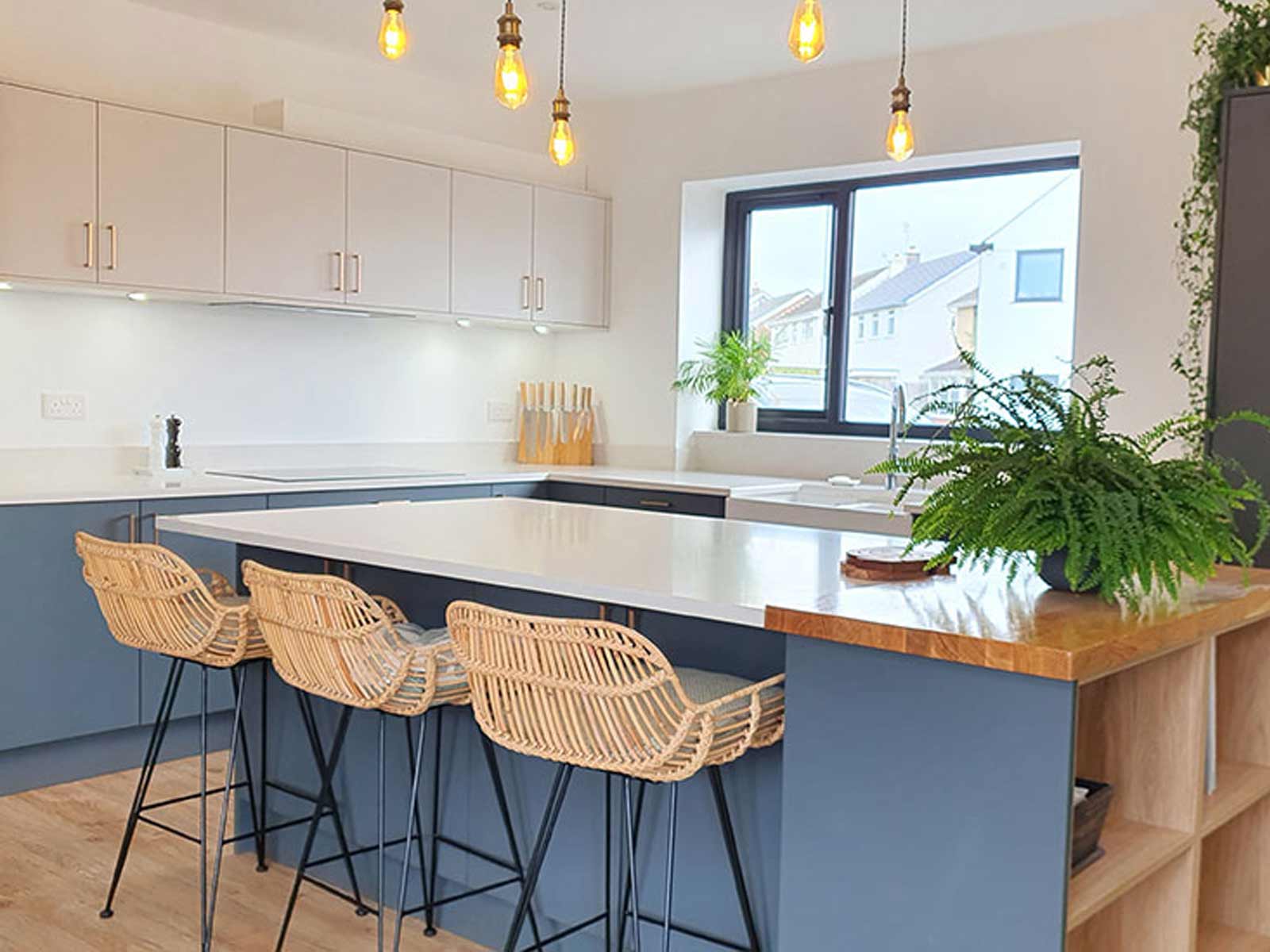 A luxury white gloss kitchen with dark blue accents and wooden shelves