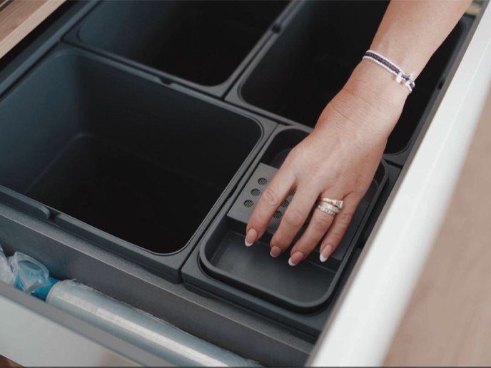 Slide-and-hide kitchen bin lids demonstrated by the homeowner