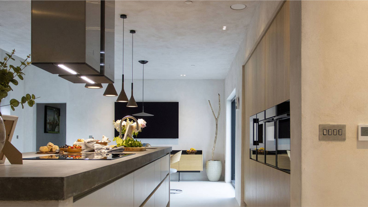 A kitchen island with a mid-century modern dining table in the background