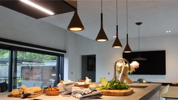 Pendant lighting over a desert modernist kitchen island