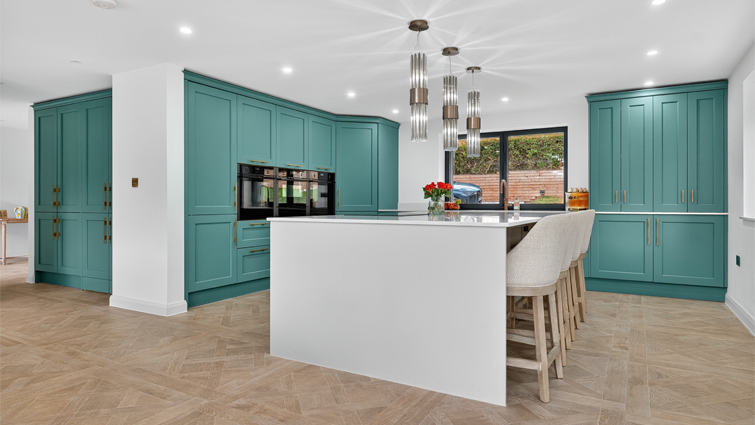 A kitchen extension with remodelled with green and grey cabinets