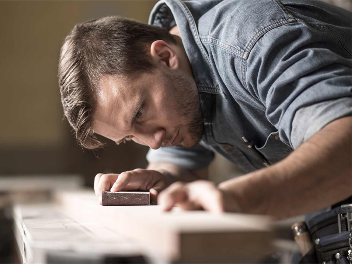 A skilled kitchen carpenter measuring wood as a kitchen fitter