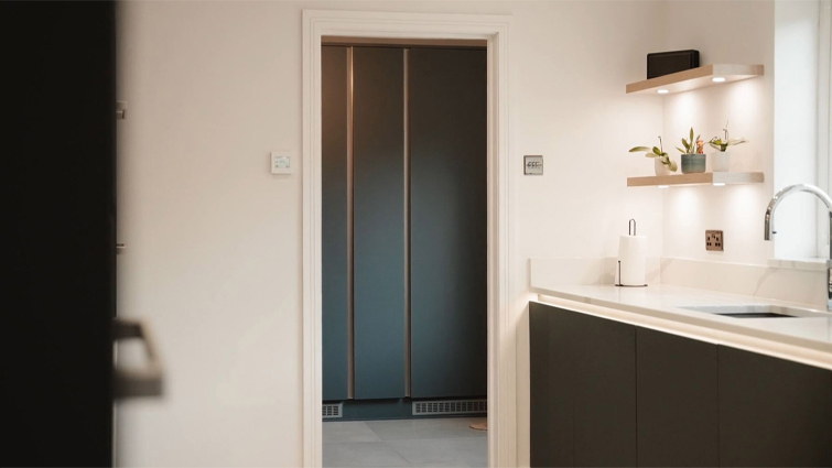 Utility cupboard and other utility room storage solutions viewed through a door
