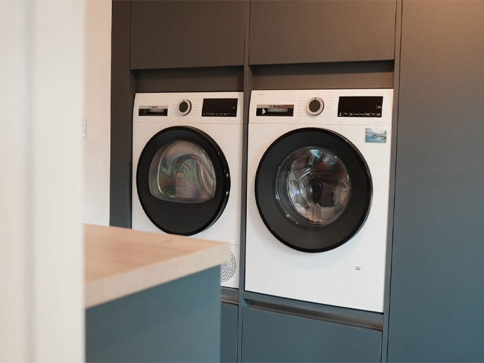 Utility room cupboards holding white goods and space for a vacuum cleaner