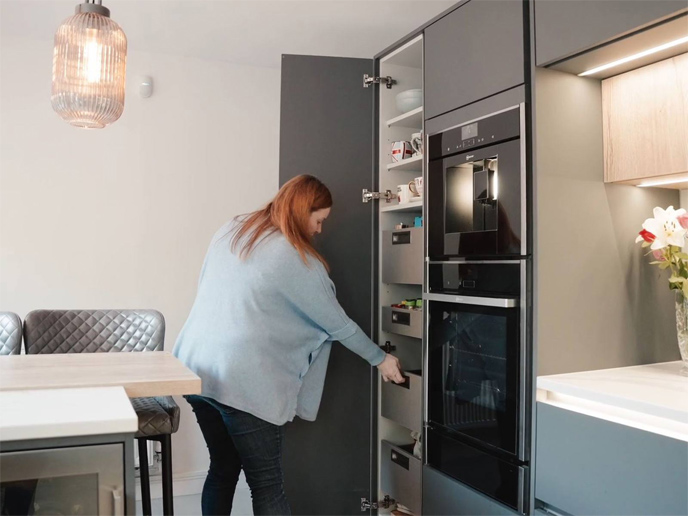 Lisa showcasing the larder in her kitchen which is a corner larder unit
