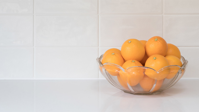 A dish of citrous fruit on a kitchen worktop ready for clove orange pomanders