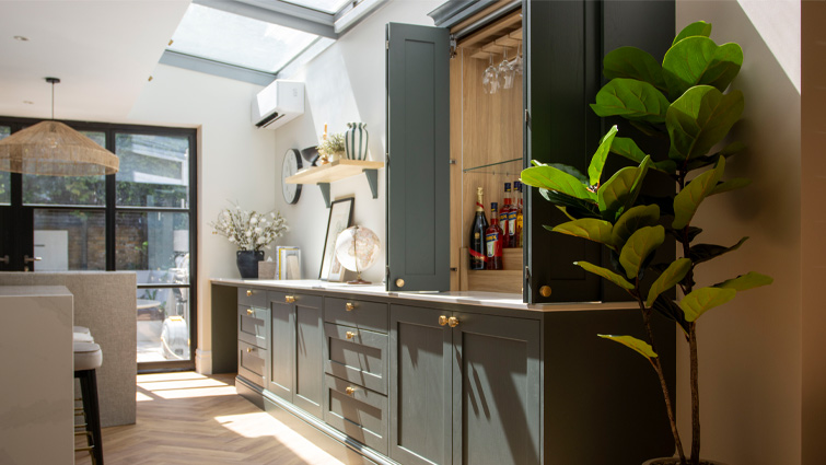 A green Mediterranean kitchen with a stocked Bar Dresser