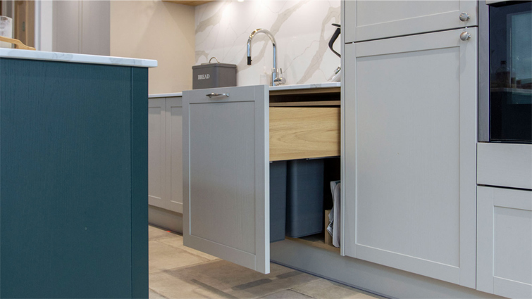 An under-cabinet bin in a small minimalist kitchen with a Scandinavian minimalism design