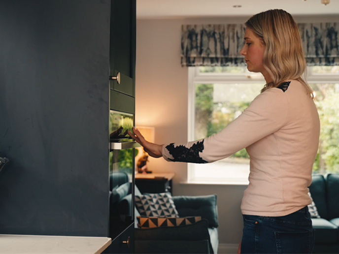 A mum in her kitchen full of integrated ovens and other appliances