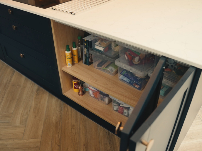 A bi-fold door kitchen cupboard with dark blue doors
