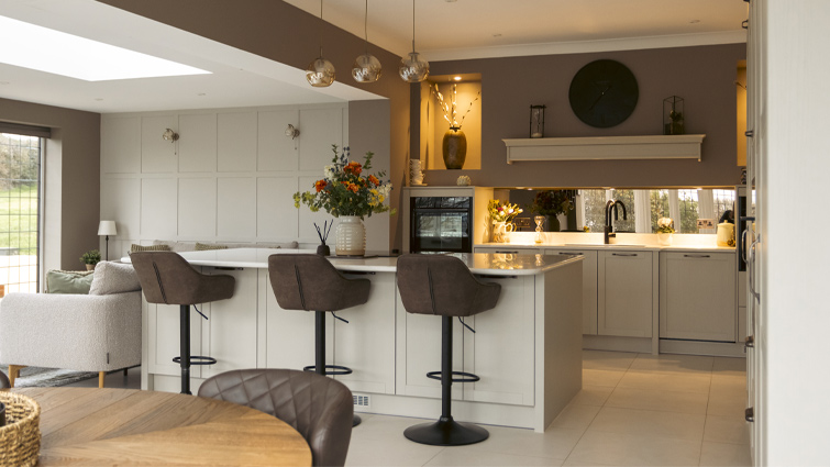 A greige kitchen with large kitchen island and mushroom walls