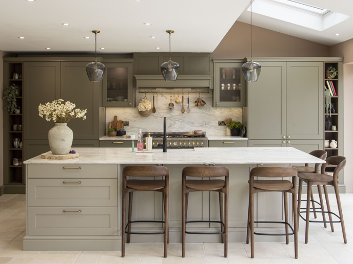 A natural earthy kitchen with dark wood furniture and green cabinets